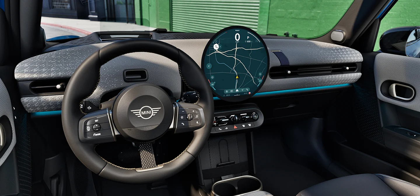 Interior view of the MINI Cooper 5-Door with focus on the steering wheel, the dashboard and the interaction unit.