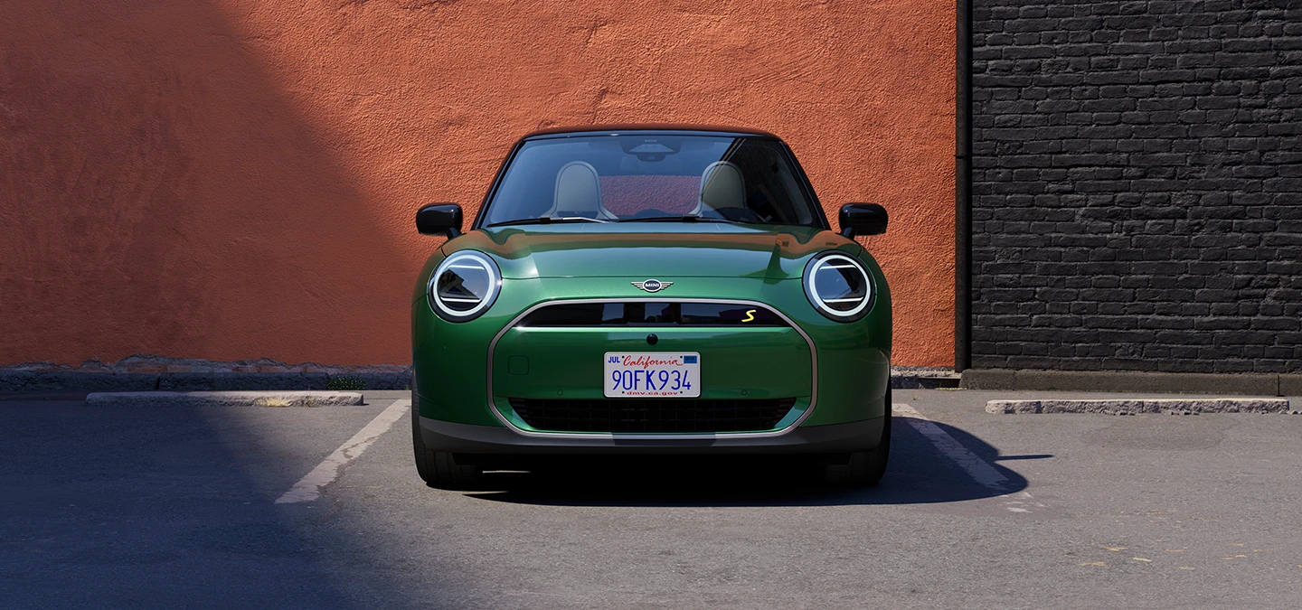 Front view of an all-electric MINI Cooper in British Racing Green and Black Roof.