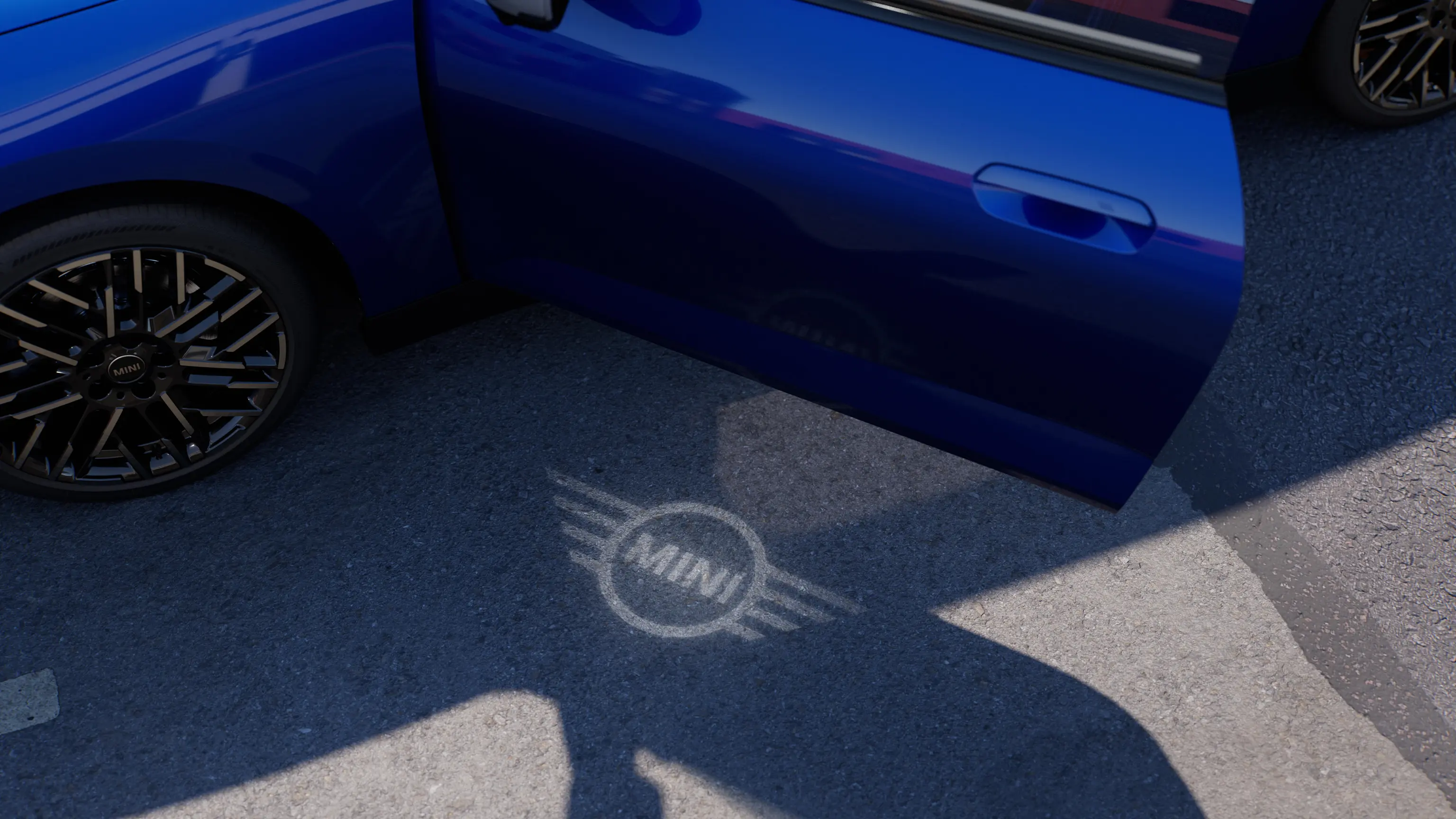 Exterior view of all-electric MINI Cooper with open door and MINI logo welcome light on the ground